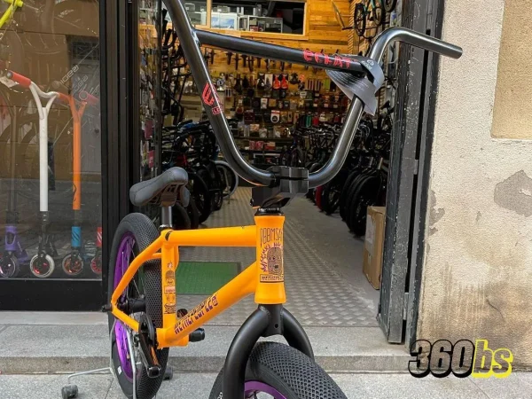 Rider de BMX realizando un truco aéreo con protección de tobilleras.