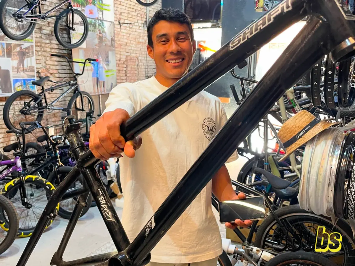 Hombre sosteniendo un cuadro de bicicleta BMX en una tienda
