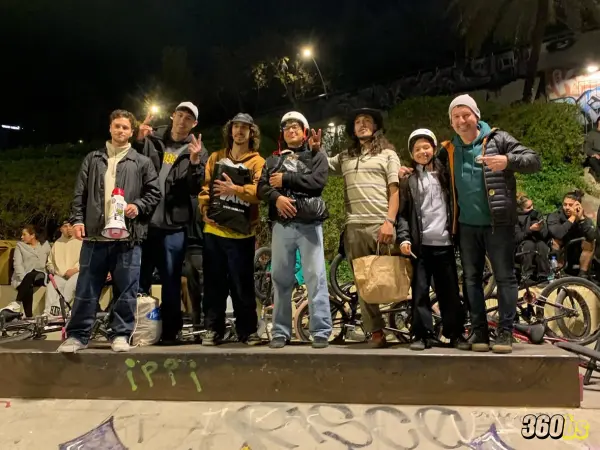 Grupo de riders en evento nocturno de BMX con ambiente urbano