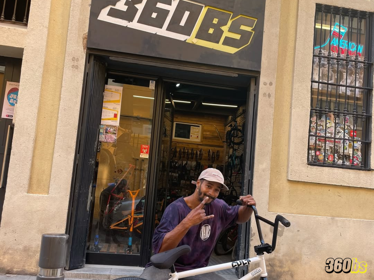 Rider posando con su BMX blanca frente a la tienda 360bs en Barcelona