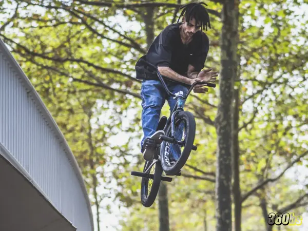 Rider BMX brakeless haciendo truco sobre barandilla sin frenos